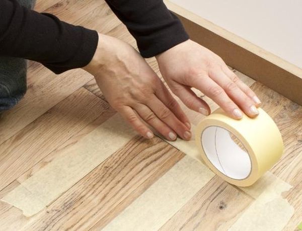 You Won't Believe How This Wood Flooring Was Renovated. applying_cellotape_wood_floor